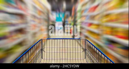 Supermarkt-Korridor mit leerem blauen Warenkorb Stockfoto