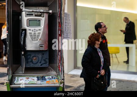 Valencia, Spanien. 15th Dez 2021. In Valencia laufen die Menschen an einer Telefonzelle vorbei.Laut dem neuen Allgemeinen Telekommunikationsgesetz (LGT) werden Telefonzellen 2022 verschwinden. Das Aussehen des Mobiltelefons war die Hauptursache für die Nichtnutzung dieser Kabinen. (Bild: © Xisco Navarro Pardo/SOPA-Bilder über ZUMA Press Wire) Stockfoto