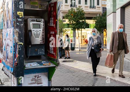 Valencia, Spanien. 15th Dez 2021. Menschen mit Masken passieren in Valencia eine Telefonzelle.Laut dem neuen Allgemeinen Telekommunikationsgesetz (LGT) werden Telefonzellen im Jahr 2022 verschwinden. Das Aussehen des Mobiltelefons war die Hauptursache für die Nichtnutzung dieser Kabinen. (Bild: © Xisco Navarro Pardo/SOPA-Bilder über ZUMA Press Wire) Stockfoto