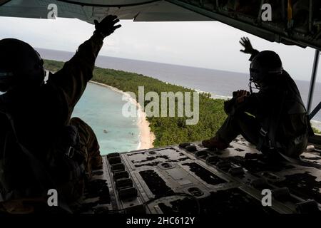 Guam. 9th Dez 2021. U.S. Air Force Airmen winken den Inselbewohnern zu, nachdem sie während der Operation Christmas Drop, die von der Andersen Air Force Base, Guam, veranstaltet wurde, Vorräte abgesetzt hatten, 9. Dezember 2021. Christmas Drop ist ein jährlicher Betrieb, der während der Weihnachtszeit mehr als 55 kleine Inseln im Pazifik beliefert. (USA Air Force Foto von Airman 1st Class Kaitlyn Preston) Quelle: U.S. Air Force/ZUMA Press Wire Service/ZUMAPRESS.com/Alamy Live News Stockfoto