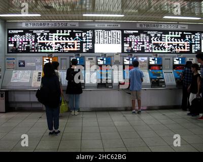 Japaner und ausländische Reisende warten und stehen in der Schlange, um Fahrkarten für den Zug am Automat der Gojo-Bahnstation zu kaufen Stockfoto