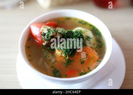 Weiße Schüssel mit Shurpa-Suppe auf dem Tisch im Restaurant Stockfoto