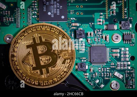 Eine Bitcoin-Münze liegt auf einer Computerplatine Stockfoto