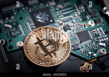 Eine Bitcoin-Münze liegt auf einer Computerplatine Stockfoto