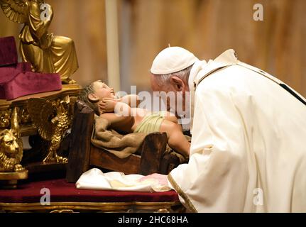 Papst Franziskus küsst eine Figur des Jesuskindes während der Feier der Weihnachtsmesse am 24. Dezember 2021 in der Petersbasilika im Vatikan. Foto von Eric Vandeville/ABACAPRESS.COM Stockfoto