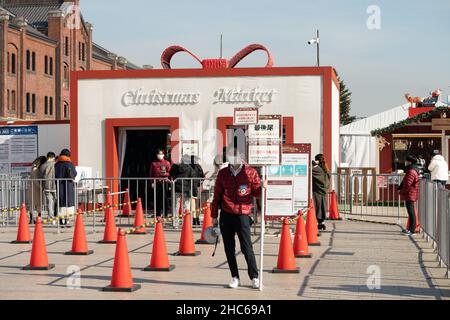 Yokohama, Japan. 24th Dez 2021. Ein Mitarbeiter hält am 24. Dezember 2021 am Eingang eines Weihnachtsmarktes im Yokohama Red Brick Warehouse in Yokohama, Japan, ein Brett mit „die heutigen Tickets sind ausverkauft“. Quelle: Sun Jialin/Xinhua/Alamy Live News Stockfoto