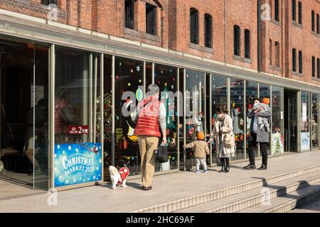 Yokohama, Japan. 24th Dez 2021. Die Menschen besuchen den Weihnachtsmarkt, der am 24. Dezember 2021 im Yokohama Red Brick Warehouse in Yokohama, Japan, abgehalten wird. Quelle: Sun Jialin/Xinhua/Alamy Live News Stockfoto