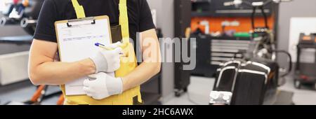Automechaniker in der Werkstatt hält die Zwischenablage für die Nahaufnahme von Aufträgen Stockfoto