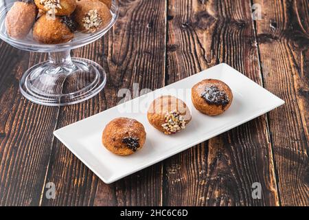 Bombolon oder Bomboloni ist ein italienisches gefülltes Donut- und Snackfutter. Deutsche Krapfen - Krapfen oder berliner - gefüllt mit Marmelade und Schokolade Stockfoto