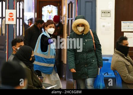 Die Menschen kommen an, um eine „Jingle Jab“-Impfimpfungs-Auffrischungsimpfung von Covid im Rathaus von Redbridge in Ilford, Essex, zu erhalten, da das Coronavirus-Auffrischungsprogramm am Weihnachtstag in ganz Großbritannien fortgesetzt wird. Bilddatum: Samstag, 25. Dezember 2021. Stockfoto