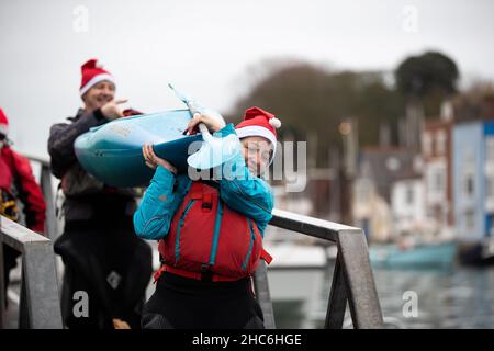 Weymouth, Großbritannien. 25th. Dezember 2021. Freiwillige Kajakfahrer beim jährlichen Weymouth Christmas Day Harbour Swim. Die Teilnehmer schwimmen über 70m zwischen den Ufern des Hafens von Weymouth und sammeln Geld für den Weymouth und den Portland Lions Club. Kredit: Liam Asman/Alamy Live Nachrichten Stockfoto