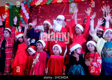 Dhaka, Bangladesch. 25th Dez 2021. Kinder posieren für ein Foto mit einem Mann, der als Weihnachtsmann gekleidet ist, während einer Weihnachtsfeier in der Hauptstadt Dhaka, Bangladesch, am 25. Dezember 2021. Kredit: Mamunur Rashid/Alamy Live Nachrichten Stockfoto