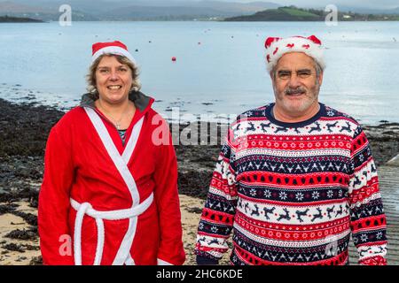 Bantry, West Cork, Irland. 25th Dez 2021. Eine Reihe von Menschen gingen heute Nachmittag in Bantry zum Weihnachtsschwimmen in einem flachen, ruhigen Meer. Sonia Taylor und Shane Begley aus Bantry bereiteten sich auf einen Sprung vor. Quelle: AG News/Alamy Live News Stockfoto