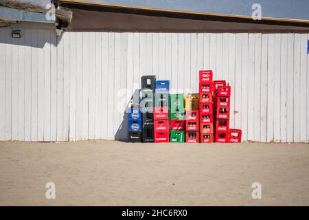 Leere Plastikkisten stapelten wieder eine Holzwand der Strandbar, Spanien. Stockfoto