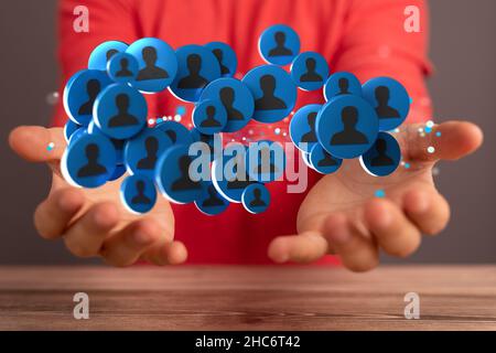 Männliche Hand hält eine Illustration einer Gruppe von Menschen - Netzwerk-Konzept Stockfoto