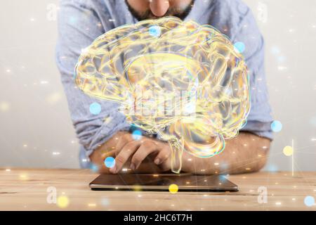 Männliche Hand zeigt auf eine Illustration eines goldenen Gehirns Stockfoto