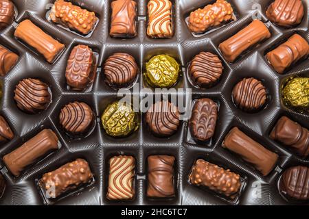 Pralinen in Einer Schachtel. Flaches Lay.Sortiment von Pralinen in einer Schachtel. Stockbild. Stockfoto