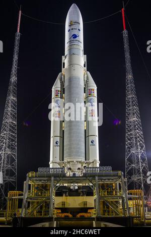 Kourou, Französisch-Guayana. 25th Dez 2021. Die Ariane 5-Rakete von Arianespace mit dem James Webb Space Telescope der NASA an Bord wird am Donnerstag, dem 23. Dezember 2021, auf der Startrampe im europäischen Weltraumbahnhof Das Weltraumzentrum Guayana in Kourou, Französisch-Guayana. Das James Webb Weltraumteleskop (manchmal auch JWST oder Webb genannt) ist ein großes Infrarotteleskop mit einem Primärspiegel von 21,3 Fuß (6,5 Meter). Das Observatorium wird jede Phase der kosmischen Geschichte untersuchen – von unserem Sonnensystem bis zu den entferntesten beobachtbaren Galaxien im frühen Universum. NASA Foto von Chris Gunn/UPI Quelle: UPI/Alamy Live News Stockfoto