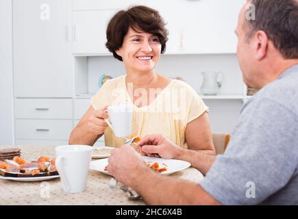 Ältere Frau, die zu Hause mit dem Mann isst. Stockfoto