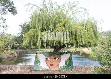 Ein Gemälde einer Frau, die auf einem Baum im botanischen Park Palma Sola in Bradenton, Florida, steht. Stockfoto