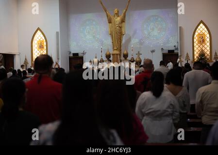 Bangkok, Thailand. 25th Dez 2021. Thailand : Christen besuchen die Heilige Kommunion anlässlich der Weihnachts- und Silvesternacht 2021 in der Holy Redentor Church in Bangkok unter dem epidemischen Coronavirus (COVID-19) Präventionsmaßnahmen wie das Tragen einer Maske, soziale Distanzierung. (Foto von Teera Noisakran/Pacific Press) Quelle: Pacific Press Media Production Corp./Alamy Live News Stockfoto