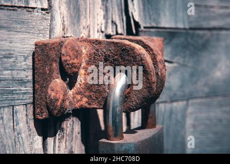 Nahaufnahme eines rostigen Schlosses an einer alten Holztür Stockfoto