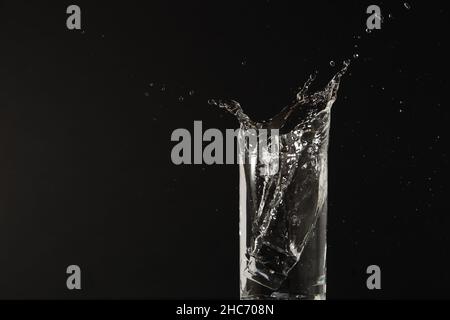 Wasser spritzt in das Glas Stockfoto