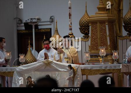 Bangkok, Thailand. 25th Dez 2021. Thailand : Christen besuchen die Heilige Kommunion anlässlich der Weihnachts- und Silvesternacht 2021 in der Holy Redentor Church in Bangkok unter dem epidemischen Coronavirus (COVID-19) Präventionsmaßnahmen wie das Tragen einer Maske, soziale Distanzierung. (Bild: © Teera Noisakran/Pacific Press via ZUMA Press Wire) Bild: ZUMA Press, Inc./Alamy Live News Stockfoto