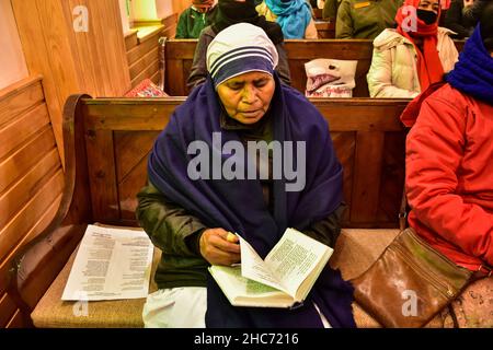 Srinagar, Indien. 25th Dez 2021. Ein christlicher Gläubiger sah während der Weihnachtszeit in Srinagar eine Bibel in der katholischen Kirche der Heiligen Familie lesen.das Kaschmir-Tal hat eine kleine Bevölkerung von Christen, Hunderte von ihnen nehmen an Weihnachten an der Messe in der katholischen Kirche der Heiligen Familie Teil und beten für Frieden und Wohlstand in der Region. Kredit: SOPA Images Limited/Alamy Live Nachrichten Stockfoto