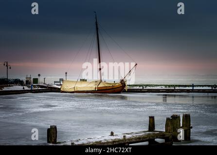Holzschiff auf Volendams gefrorenen Hafen Stockfoto