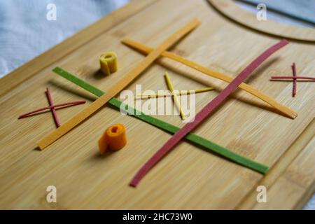 TIC-tac-toe Spiel mit hausgemachter Pasta auf einem Schneidebrett Stockfoto