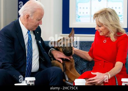 Washington, USA. 25th Dez 2021. US-Präsident Joe Biden (L) und First Lady Jill Biden (R) streicheln ihren Hund, einen Schäferhund namens „Commander“, während sie sich am Weihnachtstag im Eisenhower Executive Office Building am Weißen Haus-Komplex in Washington, DC, USA, am 25. Dezember 2021 virtuell mit Mitgliedern des US-Militärdienstes treffen. Quelle: SIPA USA/Alamy Live News Stockfoto