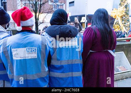 London, Großbritannien 25December 2021. NHS-Mitarbeiter und ehrenamtliche Mitarbeiter der Gemeinde verbringen ihren Weihnachtstag im Rathaus von Redbridge und bieten Coronavirus-Impfstoff und Jingle Jab für alle qualifizierten Personen als bestes Weihnachtsgeschenk seiner Art an. Sie schützen alle, da sich Omicron-Fälle alle zwei Tage verdoppeln. Quelle: Xiu Bao/Alamy Live News Stockfoto