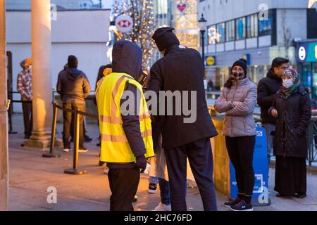 London, Großbritannien 25December 2021. NHS-Mitarbeiter und ehrenamtliche Mitarbeiter der Gemeinde verbringen ihren Weihnachtstag im Rathaus von Redbridge und bieten Coronavirus-Impfstoff und Jingle Jab für alle qualifizierten Personen als bestes Weihnachtsgeschenk seiner Art an. Sie schützen alle, da sich Omicron-Fälle alle zwei Tage verdoppeln. Quelle: Xiu Bao/Alamy Live News Stockfoto