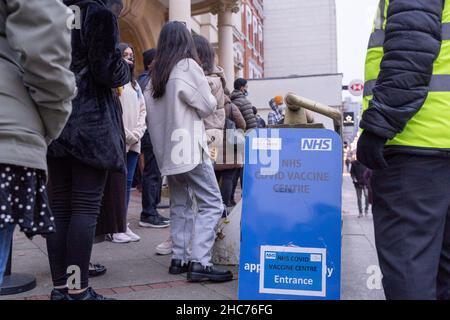 London, Großbritannien 25December 2021. NHS-Mitarbeiter und ehrenamtliche Mitarbeiter der Gemeinde verbringen ihren Weihnachtstag im Rathaus von Redbridge und bieten Coronavirus-Impfstoff und Jingle Jab für alle qualifizierten Personen als bestes Weihnachtsgeschenk seiner Art an. Sie schützen alle, da sich Omicron-Fälle alle zwei Tage verdoppeln. Quelle: Xiu Bao/Alamy Live News Stockfoto