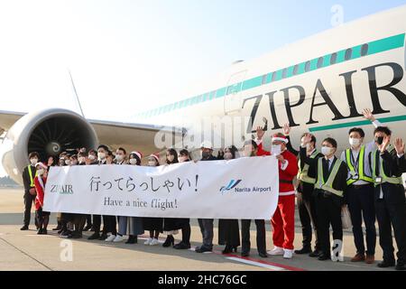 Narita, Japan. 25th Dez 2021. Die japanische Billigfluggesellschaft Zipair Tokyo, Präsident Shingo Nishida (5th R), hält in Santa-Kostümen ein Banner und schickt den ersten Flug nach Los Angeles, während die Fluggesellschaft am Samstag, dem 25. Dezember, den Flugservice zwischen Narita und Los Angeles am internationalen Flughafen Narita in Narita, einem Vorort von Tokio, einleitet. 2021. Die Low Cost-Fluggesellschaft von Japan Airlines (JAL) startete ihre sechste internationale Route nach Los Angeles. Quelle: Yoshio Tsunoda/AFLO/Alamy Live News Stockfoto