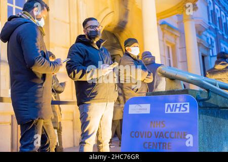 London, Großbritannien 25December 2021. NHS-Mitarbeiter und ehrenamtliche Mitarbeiter der Gemeinde verbringen ihren Weihnachtstag im Rathaus von Redbridge und bieten Coronavirus-Impfstoff und Jingle Jab für alle qualifizierten Personen als bestes Weihnachtsgeschenk seiner Art an. Sie schützen alle, da sich Omicron-Fälle alle zwei Tage verdoppeln. Quelle: Xiu Bao/Alamy Live News Stockfoto