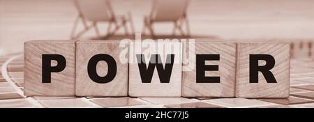 POWER Message Wort auf einem Holzwürfel Blöcke mit einem Ozean Strand Hintergrund. Geschäftsentscheidung, Bildung und Technologiekonzept. Stockfoto