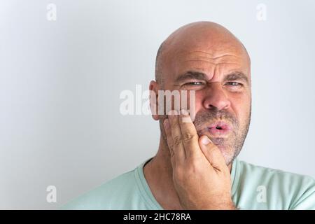 Nahaufnahme eines kahlbärtigen kaukasischen Mannes, der Zahnschmerzen ausgibt Stockfoto