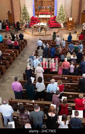 Austin, Texas, USA. 24th Dez 2021. Weihnachtssterne und Weihnachtsbäume schmücken den Altar während der Heiligabend-Gottesdienste in der Lutherischen Kirche St. Martin. Die Kirche, ein Mitglied der Evangelisch-Lutherischen Kirche von Amerika (ELCA), ist mehr als 136 Jahre alt und dient in ihrem modernen Gebäude aus der Mitte des Jahrhunderts in der Innenstadt von Austin, Texas, einer vielfältigen Bevölkerung. Kredit: Bob Daemmrich/Alamy Live Nachrichten Stockfoto