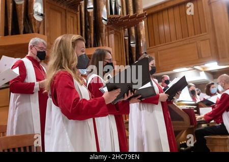 Austin, Texas, USA. 24th Dez 2021. Maskierte Chormitglieder singen während der Heiligabend-Gottesdienste in der Lutherischen Kirche St. Martin vom Chorboden aus. Die Kirche, ein Mitglied der Evangelisch-Lutherischen Kirche von Amerika (ELCA), ist mehr als 136 Jahre alt und dient in ihrem modernen Gebäude aus der Mitte des Jahrhunderts in der Innenstadt von Austin, Texas, einer vielfältigen Bevölkerung. Kredit: Bob Daemmrich/Alamy Live Nachrichten Stockfoto