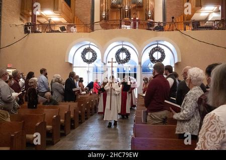 Austin, Texas, USA. 24th Dez 2021. Der Chor tritt in das Heiligtum ein, das während der Heiligabend-Gottesdienste in der Lutherischen Kirche St. Martin verborgen ist. Die Kirche, ein Mitglied der Evangelisch-Lutherischen Kirche von Amerika (ELCA), ist mehr als 136 Jahre alt und dient in ihrem modernen Gebäude aus der Mitte des Jahrhunderts in der Innenstadt von Austin, Texas, einer vielfältigen Bevölkerung. Kredit: Bob Daemmrich/Alamy Live Nachrichten Stockfoto