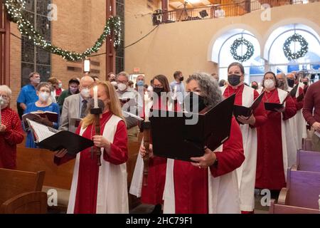 Austin, Texas, USA. 24th Dez 2021. Chormitglieder betreten das Heiligtum während der Heiligabend-Gottesdienste in der Lutherischen Kirche Saint Martin vollständig maskiert. Die Kirche, ein Mitglied der Evangelisch-Lutherischen Kirche von Amerika (ELCA), ist mehr als 136 Jahre alt und dient in ihrem modernen Gebäude aus der Mitte des Jahrhunderts in der Innenstadt von Austin, Texas, einer vielfältigen Bevölkerung. Kredit: Bob Daemmrich/Alamy Live Nachrichten Stockfoto