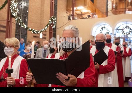 Austin, Texas, USA. 24th Dez 2021. Das Chormitglied JUDY BEGLAU tritt während der Heiligabend-Gottesdienste in der Lutherischen Kirche St. Martin vollständig maskiert in das Heiligtum ein. Die Kirche, ein Mitglied der Evangelisch-Lutherischen Kirche von Amerika (ELCA), ist mehr als 136 Jahre alt und dient in ihrem modernen Gebäude aus der Mitte des Jahrhunderts in der Innenstadt von Austin, Texas, einer vielfältigen Bevölkerung. Kredit: Bob Daemmrich/Alamy Live Nachrichten Stockfoto