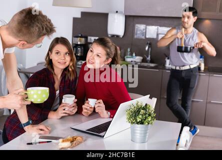 Junge Reisende mit Laptop planen touristische Reiseroute während des Frühstücks Stockfoto