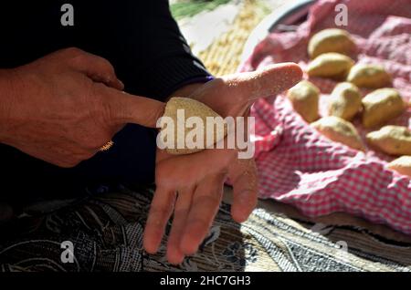 Frau, die Kibbeh mit ihrer Hand macht Stockfoto