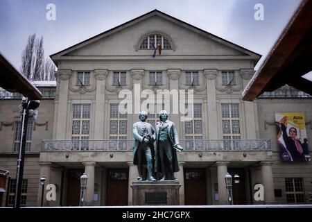 Weimar, Deutschland. 23rd Dez 2021. Das Goethe-Schiller-Denkmal am Theaterplatz ist schneebedeckt. Die bronzene Doppelstatue vor dem Deutschen Nationaltheater wurde im 19th. Jahrhundert vom Dresdner Bildhauer Ernst Rietschel entworfen. Quelle: Soeren Stache/dpa-Zentralbild/ZB/dpa/Alamy Live News Stockfoto