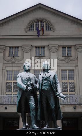 Weimar, Deutschland. 23rd Dez 2021. Das Goethe-Schiller-Denkmal am Theaterplatz ist schneebedeckt. Die bronzene Doppelstatue vor dem Deutschen Nationaltheater wurde im 19th. Jahrhundert vom Dresdner Bildhauer Ernst Rietschel entworfen. Quelle: Soeren Stache/dpa-Zentralbild/ZB/dpa/Alamy Live News Stockfoto