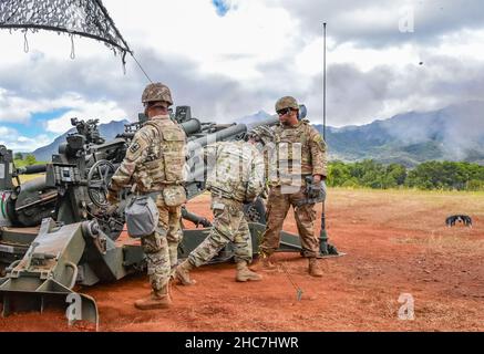 Soldaten der Hawaii Army National Guard (HIARNG) Colon. Jonathan A. Ishikawa (Mitte), 29th Infanterie-Brigade Combat Team Commander zieht die Trageschlaufe eines M777A2 155mm mittleren geschleppten Haubitzerwaffensystems, das eine Artillerierunde freigibt, während Sgt. DarwinJay Tumada (links) und CPL. Shaun DelaCalzada (rechts), beide Armeekanonen-Besatzungsmitglieder mit Charlie Battery, 1st Bataillon, 487th Field Artillery Regiment, 29th Infantry Brigade Combat Team (IBCT) stellen sicher, dass die Sicherheitsverfahren während der Kampfeinsätze der Feuermission befolgt werden, Schofield Barracks, Hawaii, 16. Juli 2021. Bekannt als der „König der Schlacht“, Feld ar Stockfoto