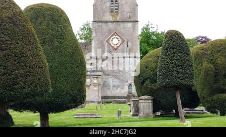 Eibe Bäume und Kirche Uhr St Marys Kirche Painswick Cotswold's Stockfoto